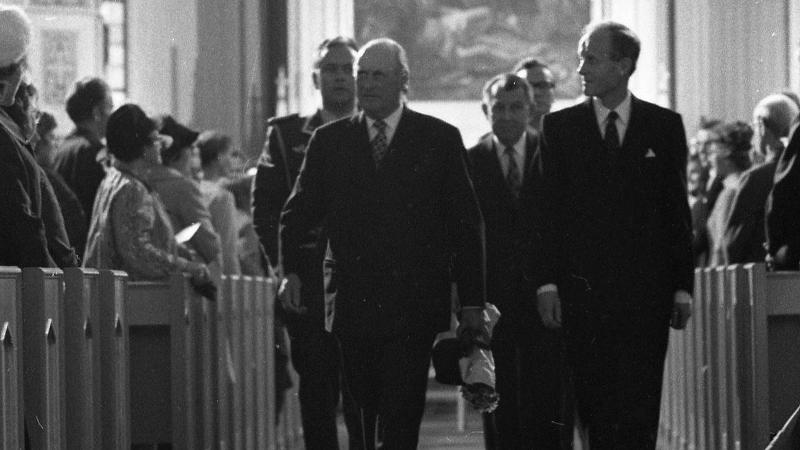 To menn leier an ut av ei kyrkje.